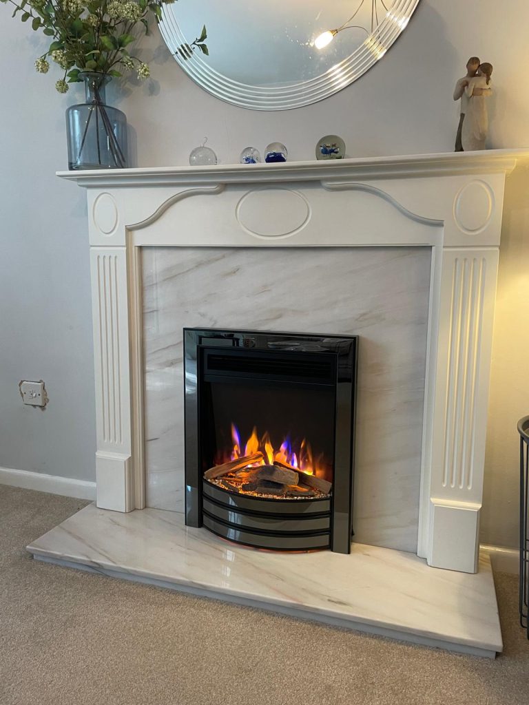 Inset electric fire in a white marble fireplace, installed by Fire Flair Direct