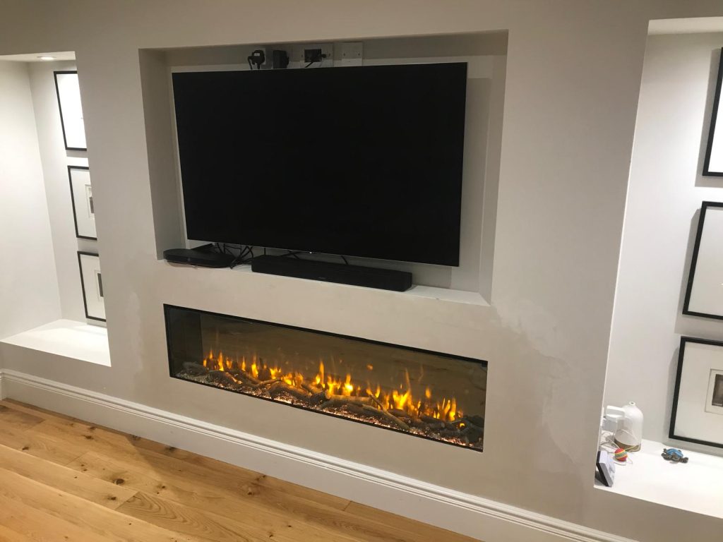Media wall with a wide electric fire beneath a TV, installed by Fire Flair Direct