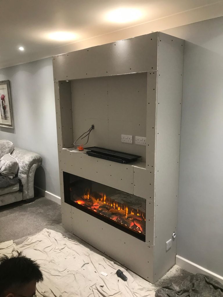 Floor-to-ceiling media wall with an inset electric fire, installed by Fire Flair Direct
