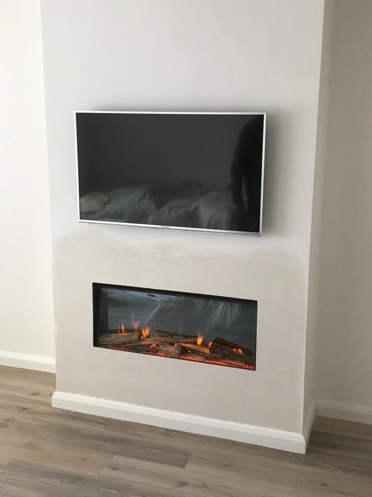 Media wall with a TV above an inset electric fire, installed by Fire Flair Direct